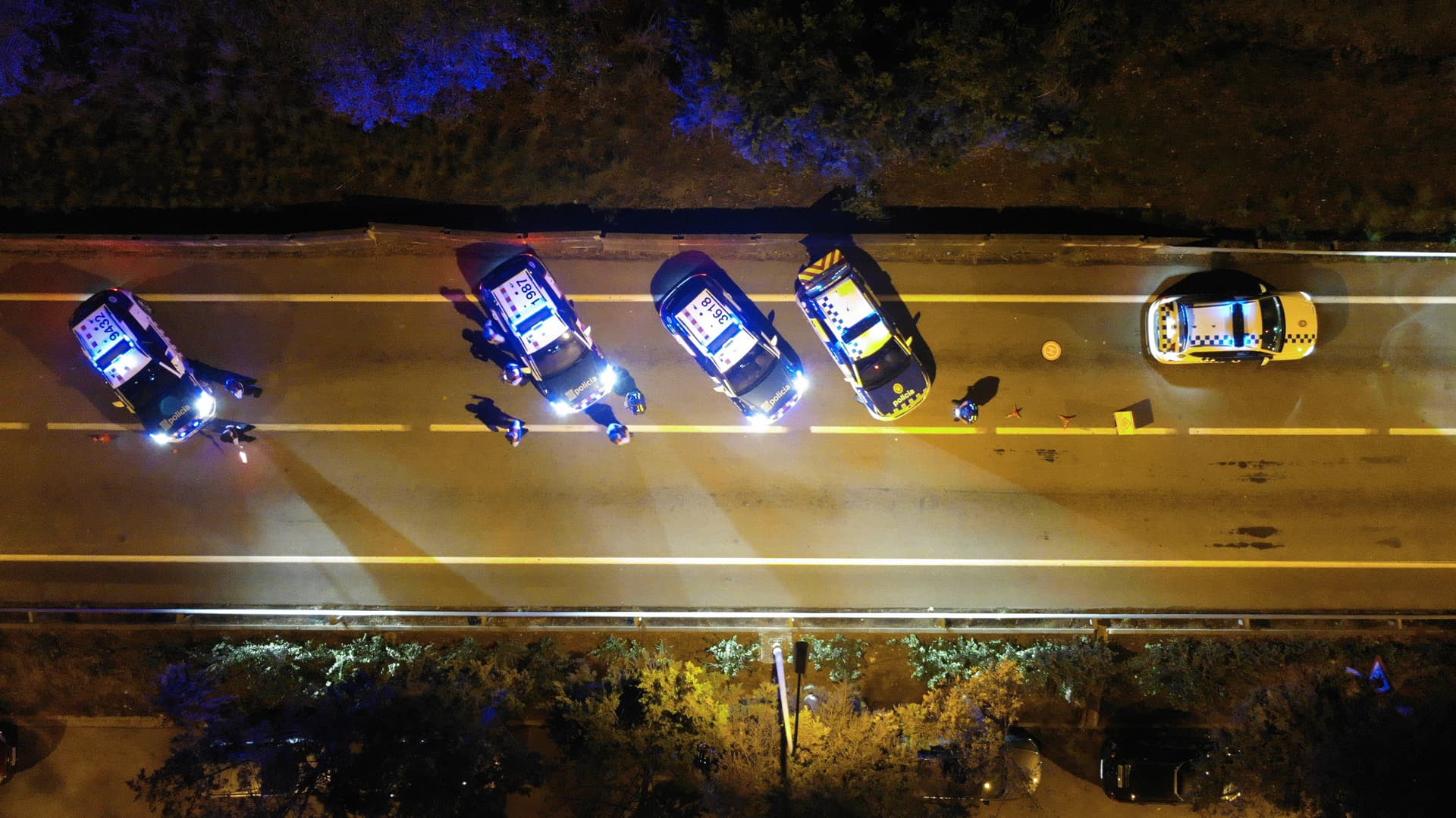 Formadores enseñando a un grupo de agentes de policía cómo realizar un control de paso en la vía pública.