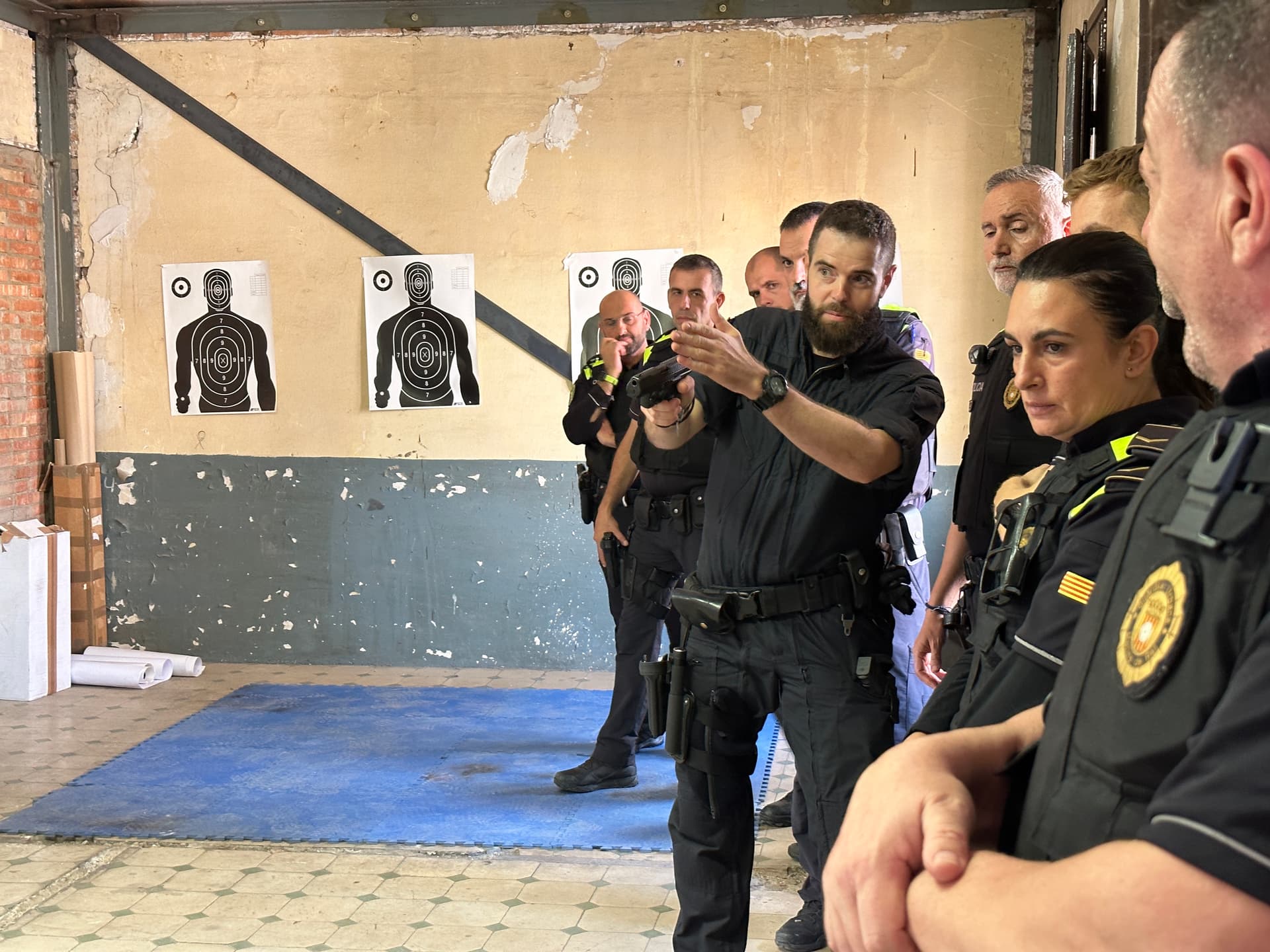 Formador enseñando a un grupo de agentes de policía cómo usar un arma de fuego.