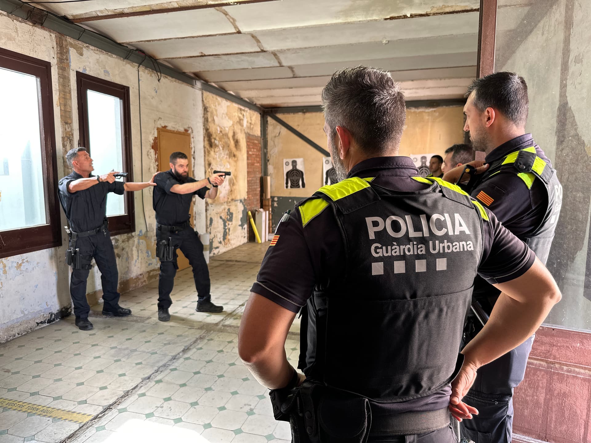 Formadores enseñando a un grupo de agentes de policía cómo realizar una entrada y registro de un inmueble.